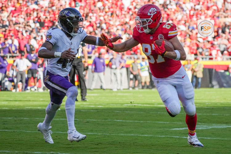 Sep 28, 2025; Kansas City, Missouri, USA; Kansas City Chiefs tight end Travis Kelce (87) runs the ball as Baltimore Ravens cornerback Marlon Humphrey (44) defends during the game at GEHA Field at Arrowhead Stadium. Credit: Denny Medley-Imagn Images