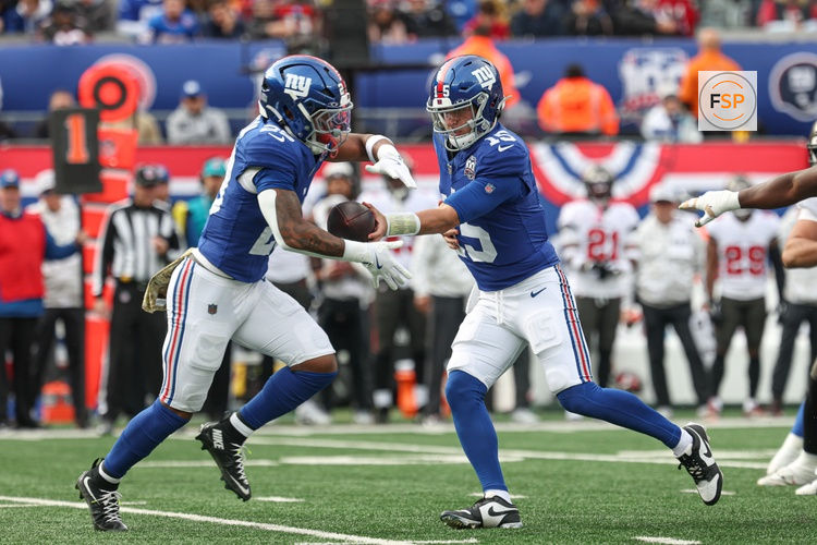 Nov 24, 2024; East Rutherford, New Jersey, USA; New York Giants quarterback Tommy DeVito (15) hands off to  running back Tyrone Tracy Jr. (29) during the first half against the Tampa Bay Buccaneers at MetLife Stadium. Credit: Vincent Carchietta-Imagn Images