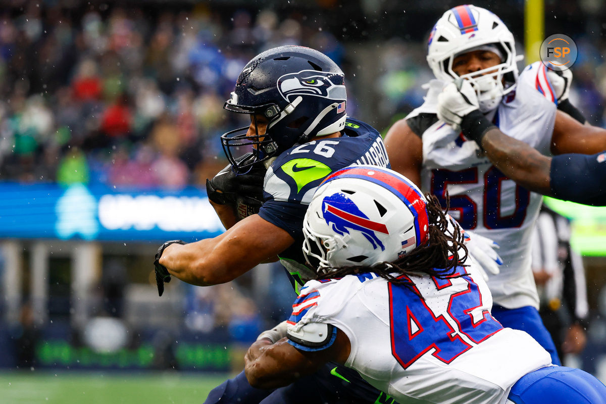 Oct 27, 2024; Seattle, Washington, USA; Seattle Seahawks running back Zach Charbonnet (26) rushes against Buffalo Bills linebacker Dorian Williams (42) during the second quarter at Lumen Field. Credit: Joe Nicholson-Imagn Images