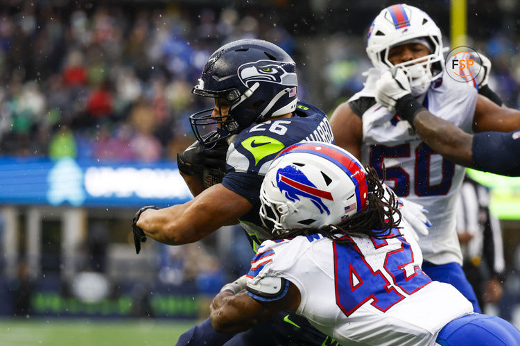 Oct 27, 2024; Seattle, Washington, USA; Seattle Seahawks running back Zach Charbonnet (26) rushes against Buffalo Bills linebacker Dorian Williams (42) during the second quarter at Lumen Field. Credit: Joe Nicholson-Imagn Images