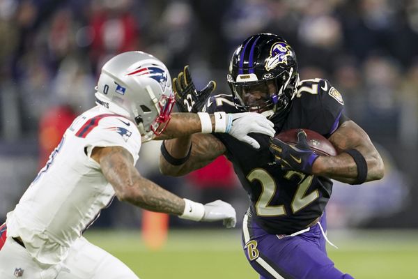 Dec 21, 2025; Baltimore, Maryland, USA;  Baltimore Ravens running back Derrick Henry (22) runs the ball against New England Patriots cornerback Christian Gonzalez (0) during the second half of the game at M&T Bank Stadium. Mandatory Credit: Mitch Stringer-Imagn Images