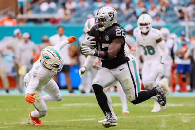 Nov 17, 2024; Miami Gardens, Florida, USA; Las Vegas Raiders running back Alexander Mattison (22) runs with the football against Miami Dolphins cornerback Kader Kohou (4) during the fourth quarter at Hard Rock Stadium. Mandatory Credit: Sam Navarro-Imagn Images