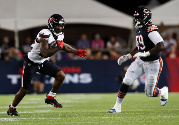 Aug 1, 2024; Canton, Ohio, USA;  Houston Texans running back Cam Akers (22) runs after a catch as Chicago Bears defensive tackle Jamree Kromah (59) chases during the second quarter at Tom Benson Hall of Fame Stadium. Mandatory Credit: Charles LeClaire-USA TODAY Sports