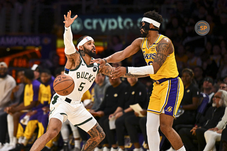 Mar 20, 2025; Los Angeles, California, USA; Los Angeles Lakers guard Jordan Goodwin (30) passes the ball against Milwaukee Bucks guard Gary Trent Jr. (5) during the first half at Crypto.com Arena. Credit: Jonathan Hui-Imagn Images