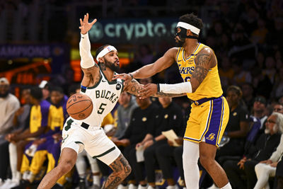 Mar 20, 2025; Los Angeles, California, USA; Los Angeles Lakers guard Jordan Goodwin (30) passes the ball against Milwaukee Bucks guard Gary Trent Jr. (5) during the first half at Crypto.com Arena. Mandatory Credit: Jonathan Hui-Imagn Images