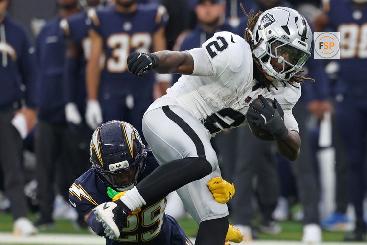 Nov 30, 2025; Inglewood, California, USA; Las Vegas Raiders running back Ashton Jeanty (2) rushes the ball past Los Angeles Chargers cornerback Tarheeb Still (29) during the second half at SoFi Stadium. Credit: Kiyoshi Mio-Imagn Images