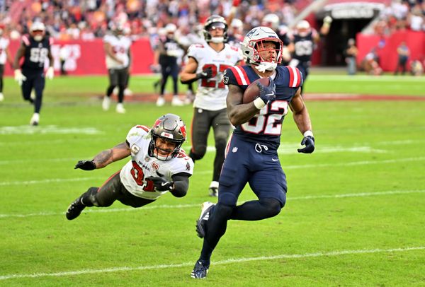 Nov 9, 2025; Tampa, Florida, USA; New England Patriots running back Treveyon Henderson (32) runs for a touchdown past Tampa Bay Buccaneers cornerback Josh Hayes (32) during the third quarter at Raymond James Stadium. Mandatory Credit: Jonathan Dyer-Imagn Images