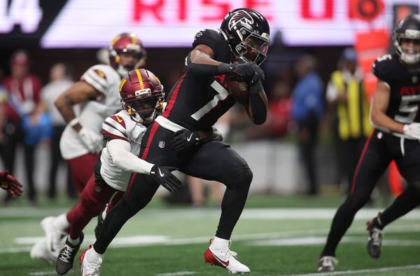 Sep 28, 2025; Atlanta, Georgia, USA; Atlanta Falcons running back Bijan Robinson (7) scores a touchdown against Washington Commanders cornerback Mike Sainristil (0) during the first half at Mercedes-Benz Stadium. Mandatory Credit: Brett Davis-Imagn Images