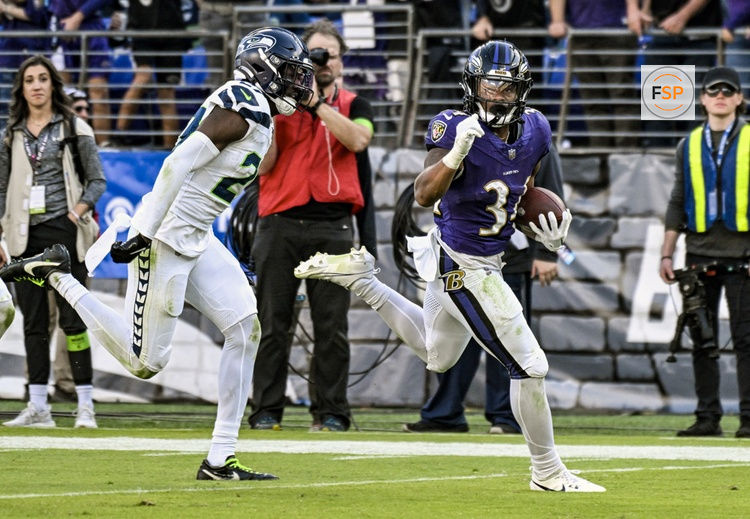 BALTIMORE, MD - NOVEMBER 05:  Baltimore Ravens running back Keaton Mitchell (34) runs for a touchdown  against Seattle Seahawks cornerback Riq Woolen (27) during the Seattle Seahawks game versus the Baltimore Ravens on November 5, 2023 at M&T Bank Stadium in Baltimore, MD.  (Photo by Mark Goldman/Icon Sportswire)