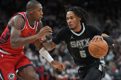 Dec 31, 2024; San Antonio, Texas, USA;  San Antonio Spurs guard Stephon Castle (5) dribbles against LA Clippers guard Kris Dunn (8) in the second half at Frost Bank Center. Mandatory Credit: Daniel Dunn-Imagn Images