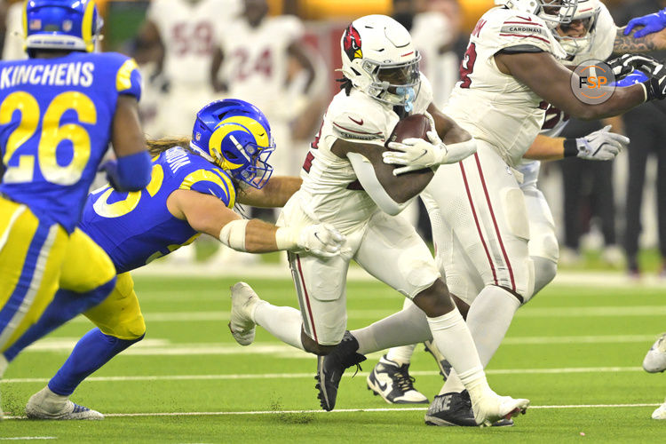 Dec 28, 2024; Inglewood, California, USA; Arizona Cardinals running back Michael Carter (22) gets past Los Angeles Rams linebacker Christian Rozeboom (56) in the second half at SoFi Stadium. Credit: Jayne Kamin-Oncea-Imagn Images