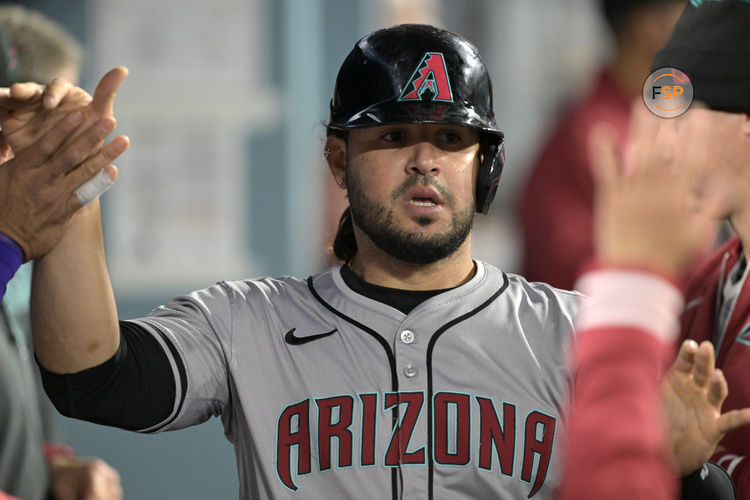 May 20, 2024; Los Angeles, California, USA;  Arizona Diamondbacks third baseman Eugenio Suarez (28) is greeted in the dugout after scoring a run in the seventh inning against the Los Angeles Dodgers at Dodger Stadium. Mandatory Credit: Jayne Kamin-Oncea-USA TODAY Sports