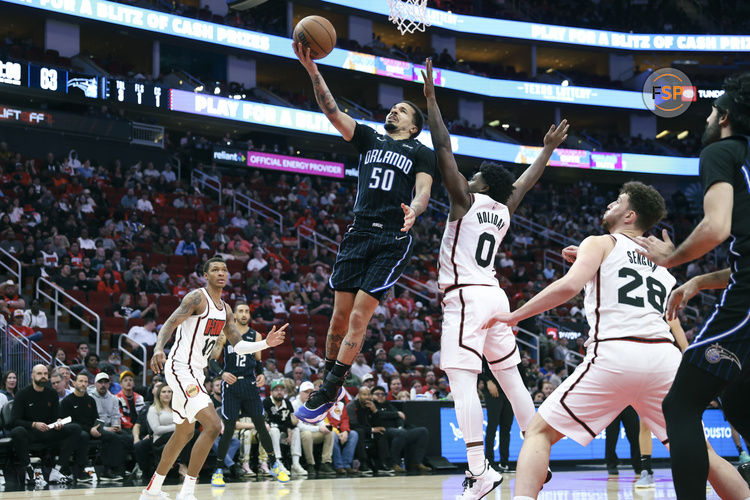 Mar 10, 2025; Houston, Texas, USA; Orlando Magic guard Cole Anthony (50) attempts to score a basket as Houston Rockets guard Aaron Holiday (0) defends during the fourth quarter at Toyota Center. Credit: Troy Taormina-Imagn Images