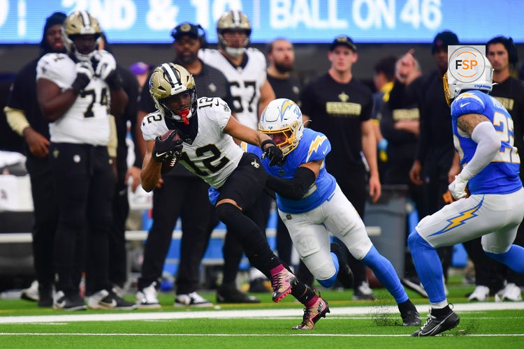 Oct 27, 2024; Inglewood, California, USA; New Orleans Saints wide receiver Chris Olave (12) runs the ball ahead of Los Angeles Chargers safety Alohi Gilman (32) during the second half at SoFi Stadium. Credit: Gary A. Vasquez-Imagn Images