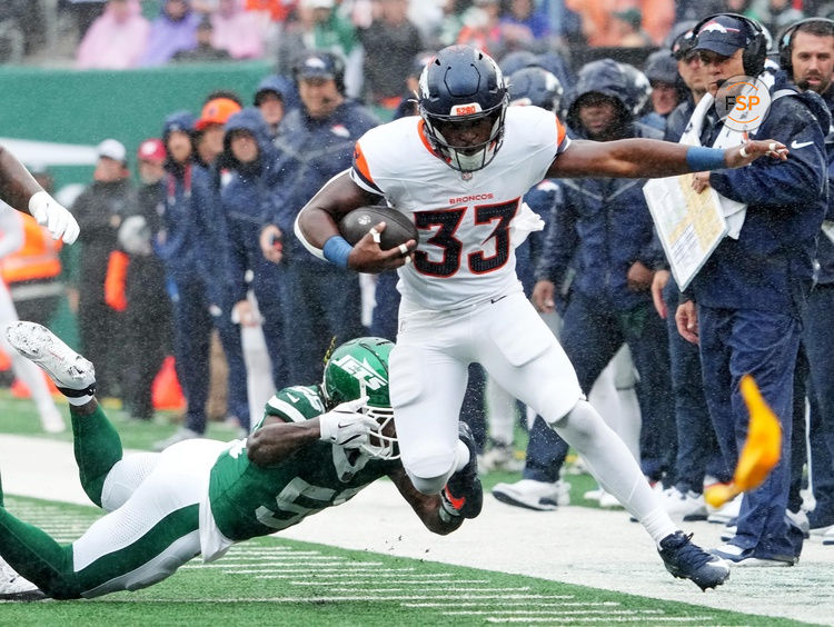 Sep 29, 2024; East Rutherford, New Jersey, USA;  Denver Broncos running back Javonte Williams (33) runs the ball against New York Jets linebacker Quincy Williams (56) during the first quarter at MetLife Stadium. Credit: Robert Deutsch-Imagn Images