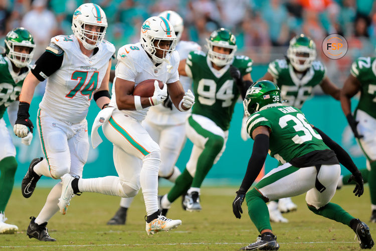 Dec 8, 2024; Miami Gardens, Florida, USA; Miami Dolphins tight end Jonnu Smith (9) runs with the football against New York Jets safety Chuck Clark (36) during overtime at Hard Rock Stadium. Credit: Sam Navarro-Imagn Images