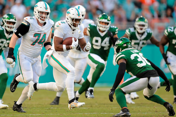 Dec 8, 2024; Miami Gardens, Florida, USA; Miami Dolphins tight end Jonnu Smith (9) runs with the football against New York Jets safety Chuck Clark (36) during overtime at Hard Rock Stadium. Mandatory Credit: Sam Navarro-Imagn Images