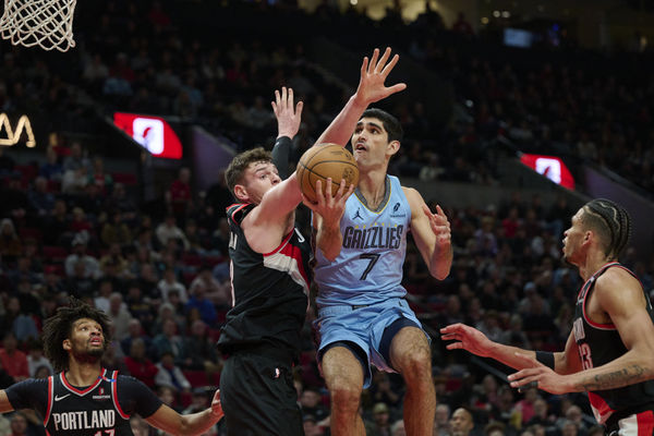 Mar 19, 2025; Portland, Oregon, USA; Memphis Grizzlies forward Santi Aldama (7) is fouled as he drives to the basket during the first half against Portland Trail Blazers center Donovan Clingan (23) at Moda Center. Mandatory Credit: Troy Wayrynen-Imagn Images