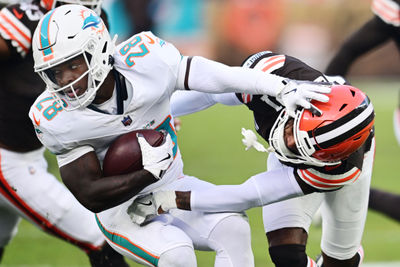 Dec 29, 2024; Cleveland, Ohio, USA; Cleveland Browns cornerback Denzel Ward (21) tackles Miami Dolphins running back De'Von Achane (28) during the first half at Huntington Bank Field. Mandatory Credit: Ken Blaze-Imagn Images