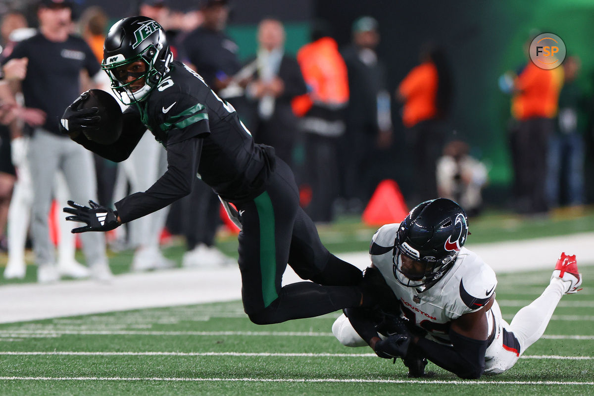 Oct 31, 2024; East Rutherford, New Jersey, USA; New York Jets wide receiver Garrett Wilson (5) runs with the ball while Houston Texans safety Eric Murray (23) attempts to tackle him during the first half at MetLife Stadium. Credit: Ed Mulholland-Imagn Images