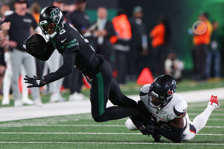 Oct 31, 2024; East Rutherford, New Jersey, USA; New York Jets wide receiver Garrett Wilson (5) runs with the ball while Houston Texans safety Eric Murray (23) attempts to tackle him during the first half at MetLife Stadium. Credit: Ed Mulholland-Imagn Images