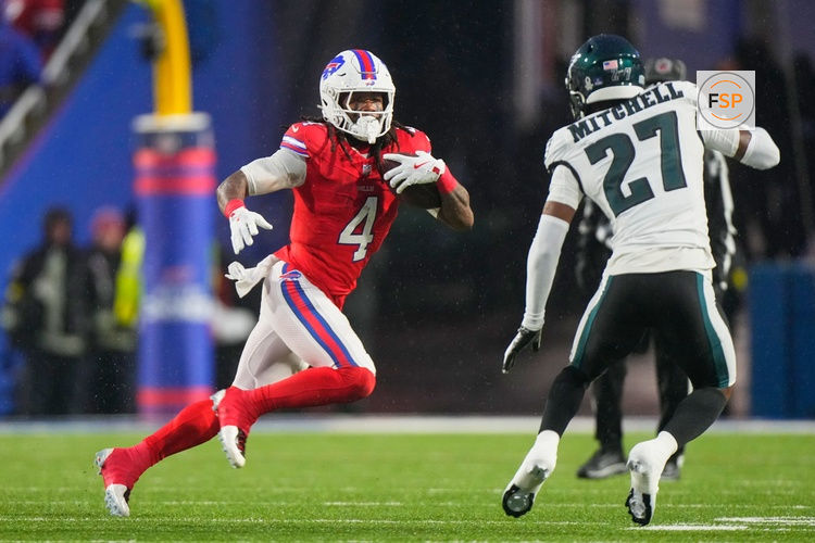 Dec 28, 2025; Orchard Park, New York, USA; Buffalo Bills running back James Cook III (4) runs the ball against Philadelphia Eagles cornerback Quinyon Mitchell (27) during the first quarter at Highmark Stadium. Credit: Gregory Fisher-Imagn Images
