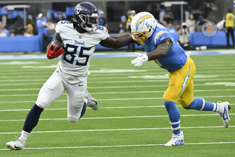 Nov 10, 2024; Inglewood, California, USA; Tennessee Titans tight end Chig Okonkwo (85) stiff arms Los Angeles Chargers linebacker Denzel Perryman (6) during the third quarter at SoFi Stadium. Credit: Robert Hanashiro-Imagn Images