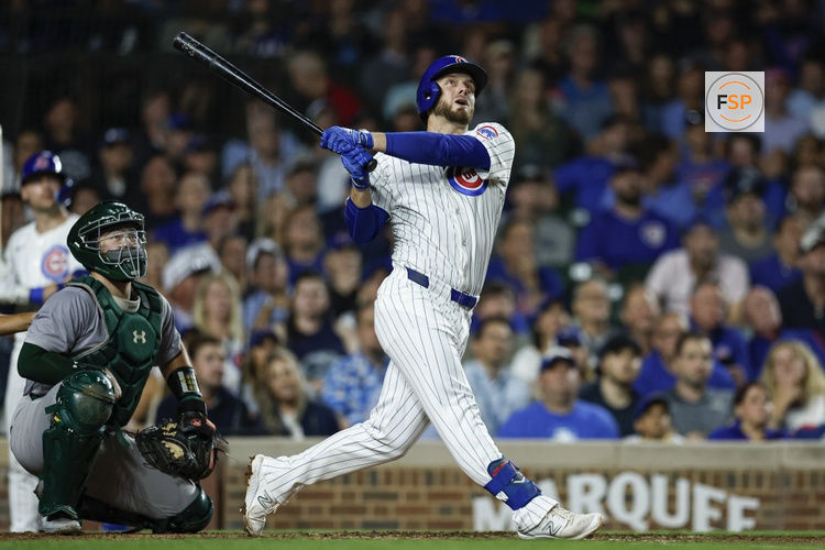 Sep 17, 2024; Chicago, Illinois, USA; Chicago Cubs first baseman Michael Busch (29) hits an RBI-single against the Oakland Athletics during the third inning at Wrigley Field. Credit: Kamil Krzaczynski-Imagn Images