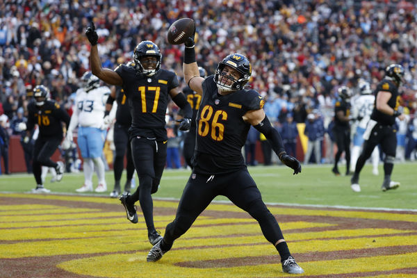 Dec 1, 2024; Landover, Maryland, USA; Washington Commanders tight end Zach Ertz (86) spikes the ball in the end zone after catching a touchdown pass as Commanders wide receiver Terry McLaurin (17) celebrates against the Tennessee Titans during the fourth quarter at Northwest Stadium. Mandatory Credit: Geoff Burke-Imagn Images