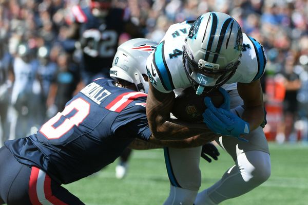 Sep 28, 2025; Foxborough, Massachusetts, USA; New England Patriots cornerback Christian Gonzalez (0) tackles Carolina Panthers wide receiver Tetairoa McMillan (4) during the first half at Gillette Stadium. Mandatory Credit: Bob DeChiara-Imagn Images