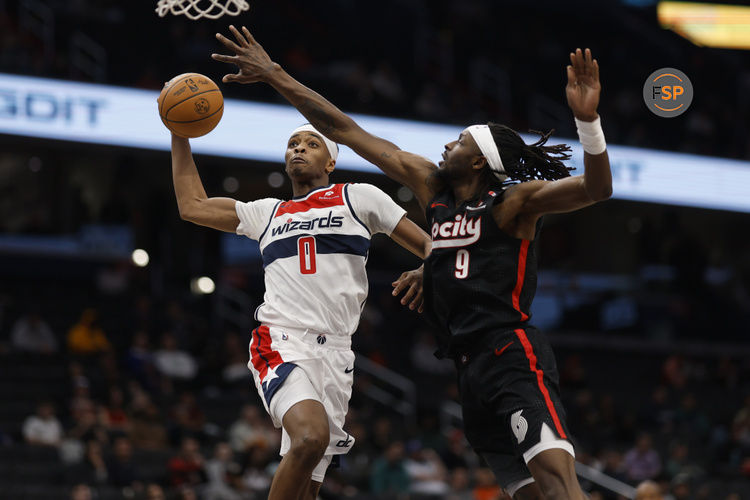 Feb 26, 2025; Washington, District of Columbia, USA; Washington Wizards guard Bilal Coulibaly (0) dunks the ball as Portland Trail Blazers forward Jerami Grant (9) defends in the second half at Capital One Arena. Credit: Geoff Burke-Imagn Images