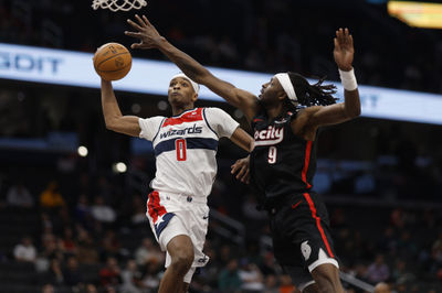 Feb 26, 2025; Washington, District of Columbia, USA; Washington Wizards guard Bilal Coulibaly (0) dunks the ball as Portland Trail Blazers forward Jerami Grant (9) defends in the second half at Capital One Arena. Mandatory Credit: Geoff Burke-Imagn Images