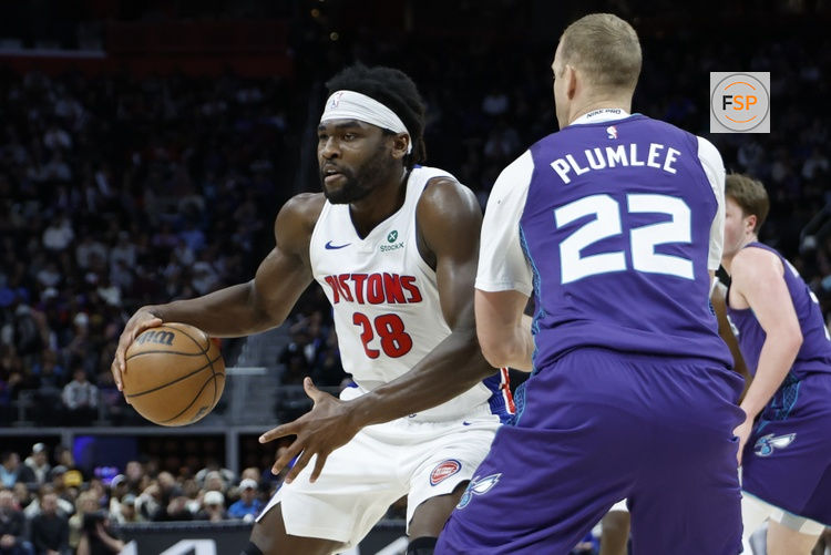 Dec 20, 2025; Detroit, Michigan, USA;  Detroit Pistons forward Isaiah Stewart (28) dribbles defended by Charlotte Hornets center Mason Plumlee (22) in the first half at Little Caesars Arena. Credit: Rick Osentoski-Imagn Images