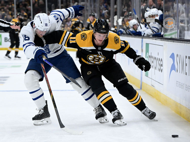 Feb 25, 2025; Boston, Massachusetts, USA; Boston Bruins center Trent Frederic (11) skates with the puck against Toronto Maple Leafs center Steven Lorentz (18) during the first period at the TD Garden. Credit: Brian Fluharty-Imagn Images