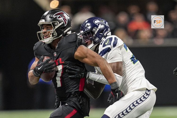 Dec 7, 2025; Atlanta, Georgia, USA; Atlanta Falcons running back Bijan Robinson (7) is tackled by Seattle Seahawks cornerback Riq Woolen (27) at Mercedes-Benz Stadium. Credit: Dale Zanine-Imagn Images