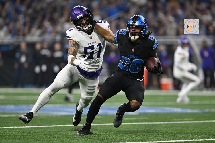 Jan 5, 2025; Detroit, Michigan, USA; Detroit Lions running back Jahmyr Gibbs (26) stiff arms Minnesota Vikings linebacker Blake Cashman (51) on his way to a first down in the first quarter at Ford Field. Credit: Lon Horwedel-Imagn Images