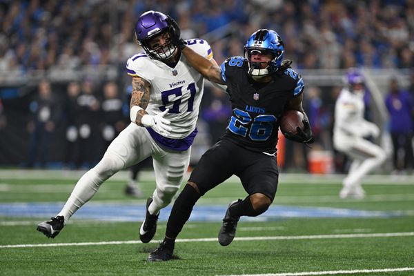 Jan 5, 2025; Detroit, Michigan, USA; Detroit Lions running back Jahmyr Gibbs (26) stiff arms Minnesota Vikings linebacker Blake Cashman (51) on his way to a first down in the first quarter at Ford Field. Mandatory Credit: Lon Horwedel-Imagn Images