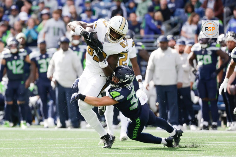 Sep 21, 2025; Seattle, Washington, USA; Seattle Seahawks safety Ty Okada (39) tackles New Orleans Saints tight end Juwan Johnson (83) following the catch during the first quarter at Lumen Field. Credit: Joe Nicholson-Imagn Images