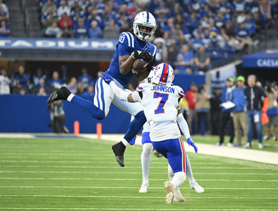 Nov 10, 2024; Indianapolis, Indiana, USA; Indianapolis Colts wide receiver Adonai Mitchell (10) catches the ball in front of Buffalo Bills cornerback Taron Johnson (7) during the second half at Lucas Oil Stadium. Mandatory Credit: Marc Lebryk-Imagn Images