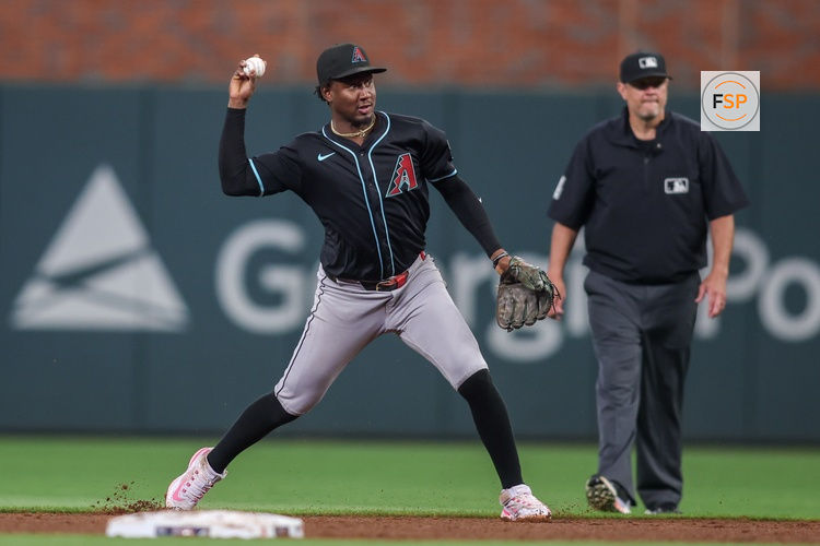 Jun 4, 2025; Atlanta, Georgia, USA; Arizona Diamondbacks shortstop Geraldo Perdomo (2) turns a double play against the Atlanta Braves in the sixth inning at Truist Park. Credit: Brett Davis-Imagn Images