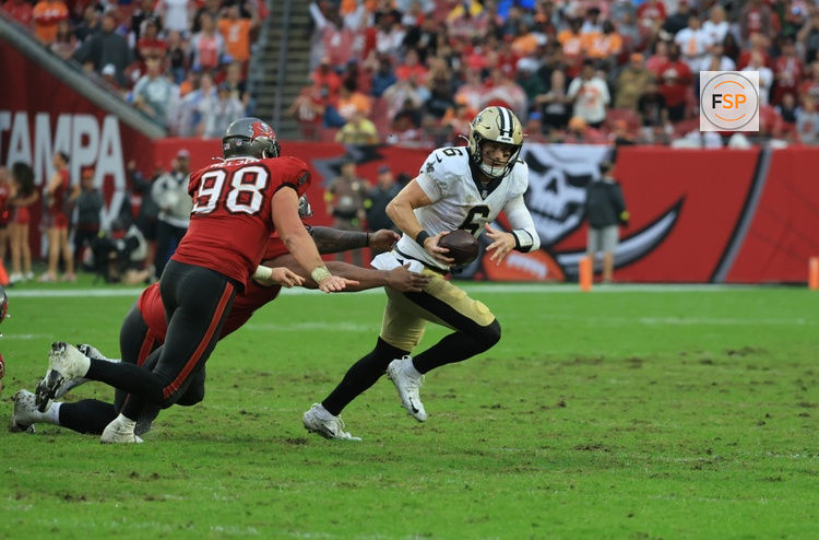 Dec 7, 2025; Tampa, Florida, USA; New Orleans Saints quarterback Tyler Shough (6) runs for a gain past Tampa Bay Buccaneers linebacker Anthony Nelson (98) during the fourth quarter at Raymond James Stadium. Credit: Kim Klement Neitzel-Imagn Images