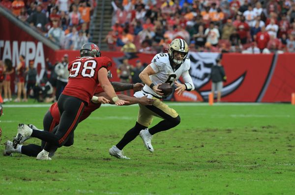 Dec 7, 2025; Tampa, Florida, USA; New Orleans Saints quarterback Tyler Shough (6) runs for a gain past Tampa Bay Buccaneers linebacker Anthony Nelson (98) during the fourth quarter at Raymond James Stadium. Mandatory Credit: Kim Klement Neitzel-Imagn Images