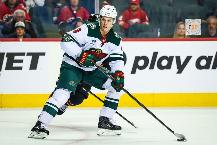 Dec 4, 2025; Calgary, Alberta, CAN; Minnesota Wild defenseman Zeev Buium (8) controls the puck against the Calgary Flames during the first period at Scotiabank Saddledome. Credit: Sergei Belski-Imagn Images