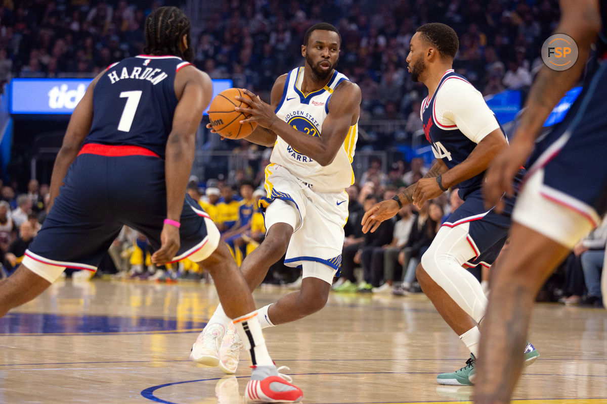 Oct 27, 2024; San Francisco, California, USA; Golden State Warriors forward Andrew Wiggins (22) drives to the basket between Los Angeles Clippers guards James Harden (1) and Norman Powell (24) during the first quarter at Chase Center. Credit: D. Ross Cameron-Imagn Images