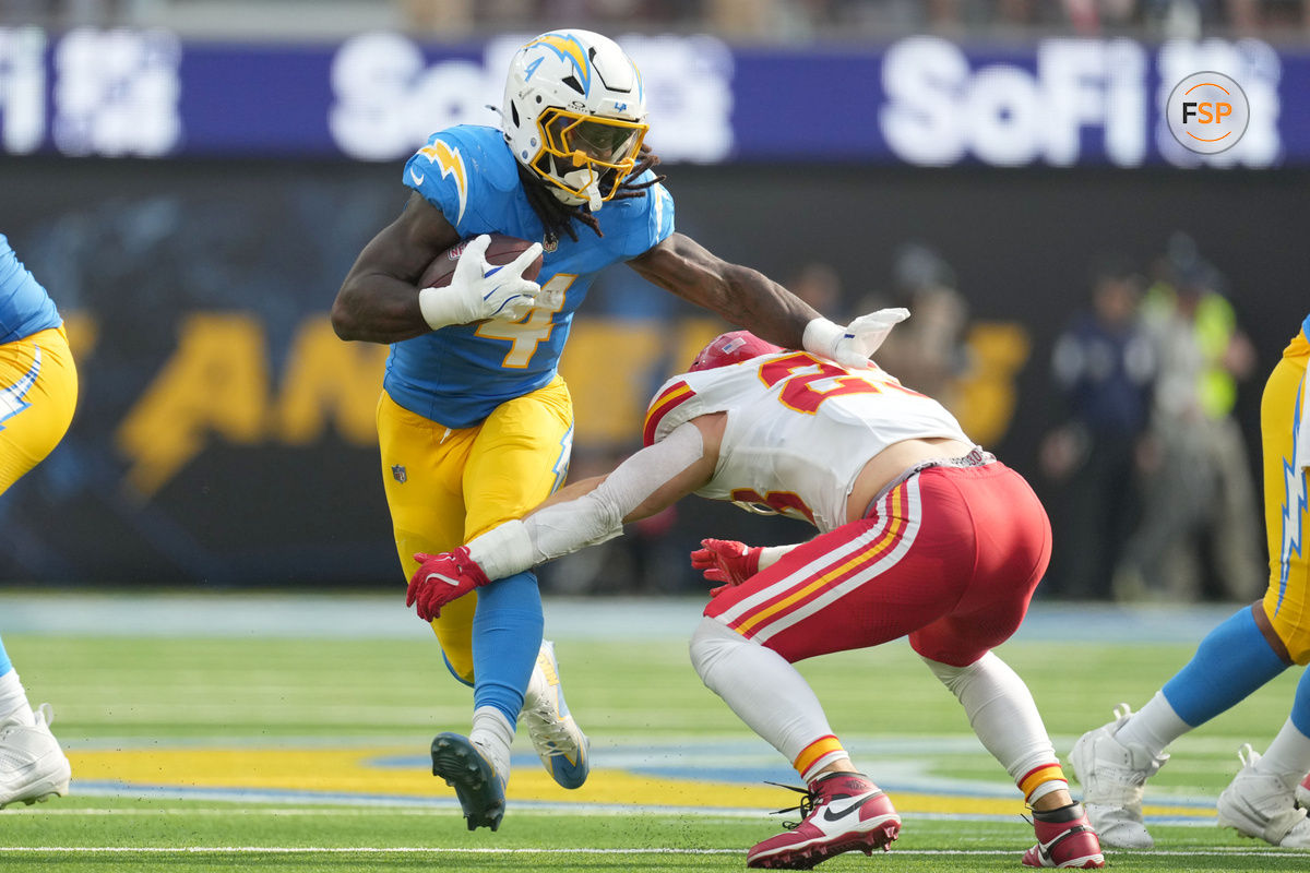 Sep 29, 2024; Inglewood, California, USA; Los Angeles Chargers running back Gus Edwards (4) carries the ball against Kansas City Chiefs linebacker Drue Tranquill (23) in the second half at SoFi Stadium. Credit: Kirby Lee-Imagn Images