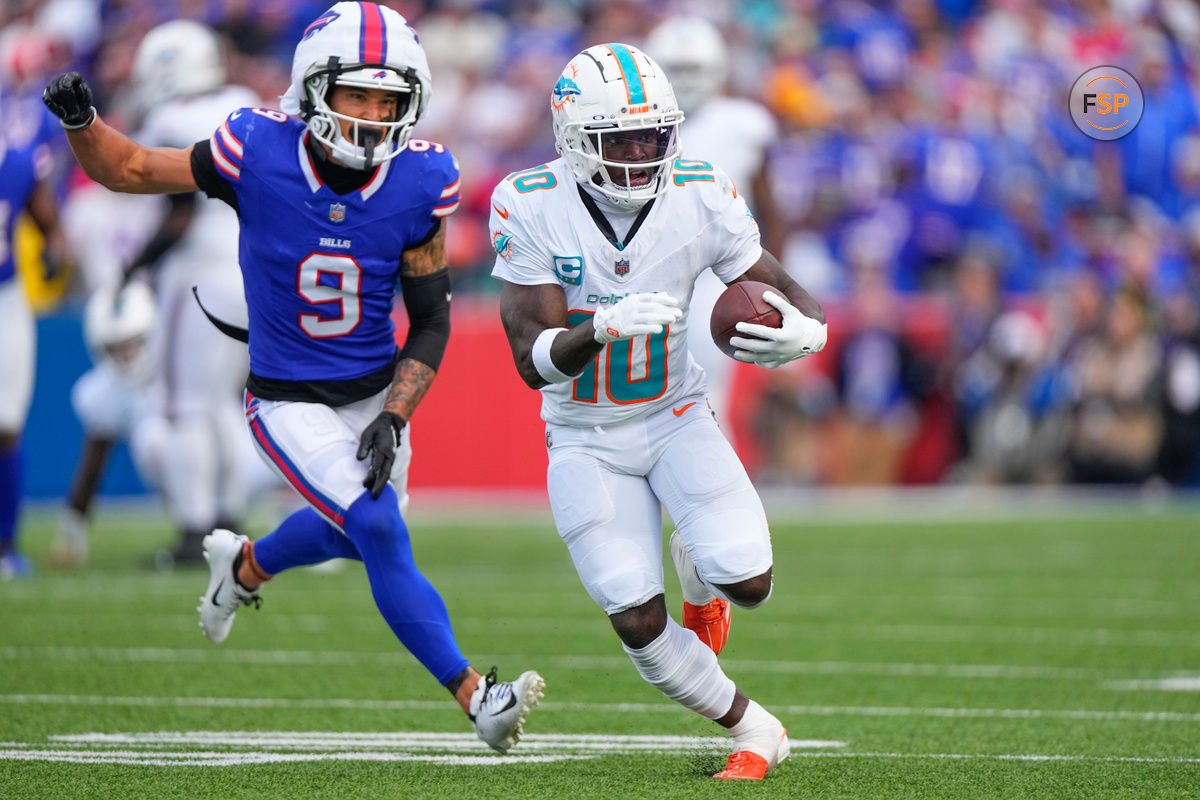 Nov 3, 2024; Orchard Park, New York, USA; Miami Dolphins wide receiver Tyreek Hill (10) runs with the ball against Buffalo Bills safety Taylor Rapp (9) during the second half at Highmark Stadium. Credit: Gregory Fisher-Imagn Images