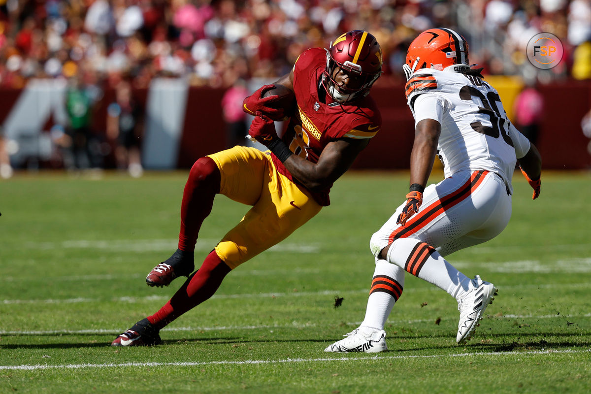 Oct 6, 2024; Landover, Maryland, USA; Washington Commanders running back Brian Robinson Jr. (8) carries the ball as Cleveland Browns linebacker Devin Bush (30) defends during the second quarter at NorthWest Stadium. Credit: Geoff Burke-Imagn Images