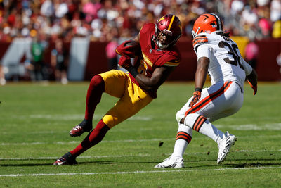 Oct 6, 2024; Landover, Maryland, USA; Washington Commanders running back Brian Robinson Jr. (8) carries the ball as Cleveland Browns linebacker Devin Bush (30) defends during the second quarter at NorthWest Stadium. Mandatory Credit: Geoff Burke-Imagn Images