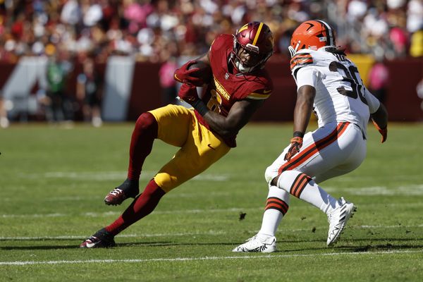 Oct 6, 2024; Landover, Maryland, USA; Washington Commanders running back Brian Robinson Jr. (8) carries the ball as Cleveland Browns linebacker Devin Bush (30) defends during the second quarter at NorthWest Stadium. Mandatory Credit: Geoff Burke-Imagn Images
