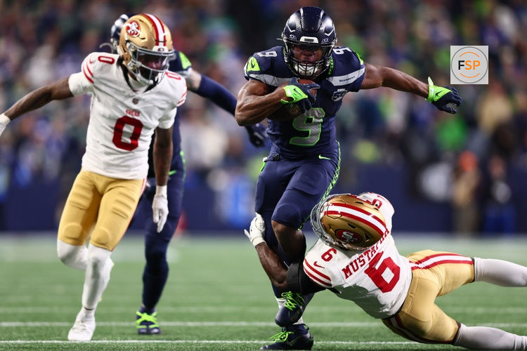Jan 17, 2026; Seattle, WA, USA; Seattle Seahawks running back Kenneth Walker III (9) carries the ball as San Francisco 49ers safety Malik Mustapha (6) defends during the second half in an NFC Divisional Round game at Lumen Field. Credit: Kevin Ng-Imagn Images